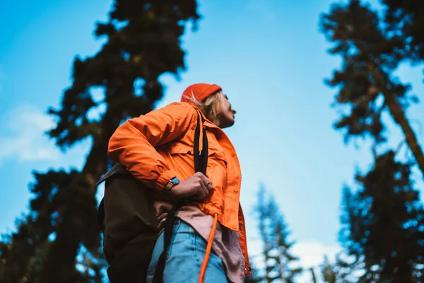 Hippi kız yolculuk tutkusu keşfetmek orman vahşi doğa ile yaz aylarında turistik sırt çantası, Genç kadın uzun yürüyüşe çıkan kimse turuncu ceketli keşfetmek yollar Ulusal par yolculuk sırasında macera sahip ahşap