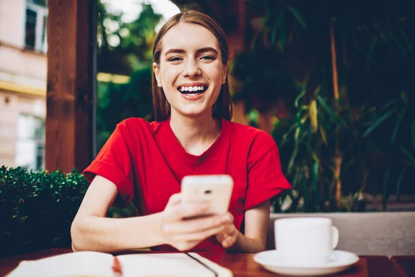 Yarım uzunluk portre fotoğraf makinesi vasıl yüksek hız 4 g internet bağlantısı ile smartphone için yeni app yüklerken gülüyor neşeli şirin Blogger. Pozitif kadın cep üzerinde komik bildirimi alındı