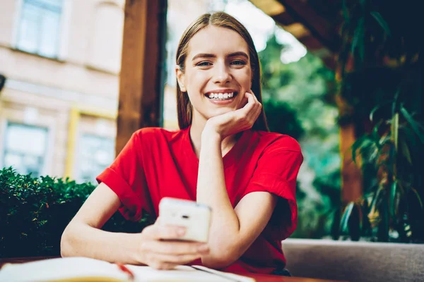 Neşeli başarılı kadın kameraya kendi profil sayfası kameraya bakarak telefon güncelleştirilirken gülümseyen, yarı uzunluk portre. Hareket eden telefon bekleyen geribildirim takipçileri ile pozitif blogger