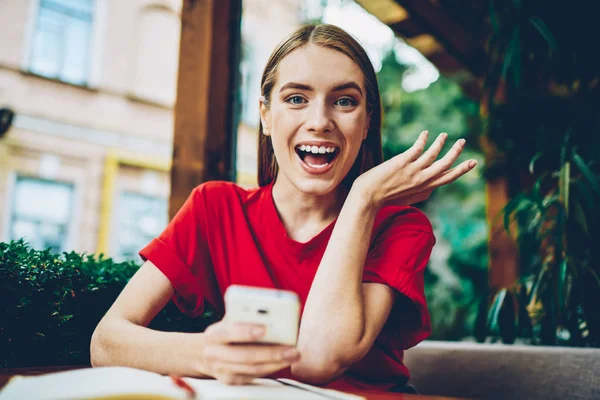 Yarım uzunluk portre duygusal mutlu genç kadının tarife planı operatör için mobil yararları sürpriz. Smartphone aygıt üzerinde ücretsiz gezici çağrılarla olumlu şok kadın alınan sms mesajı