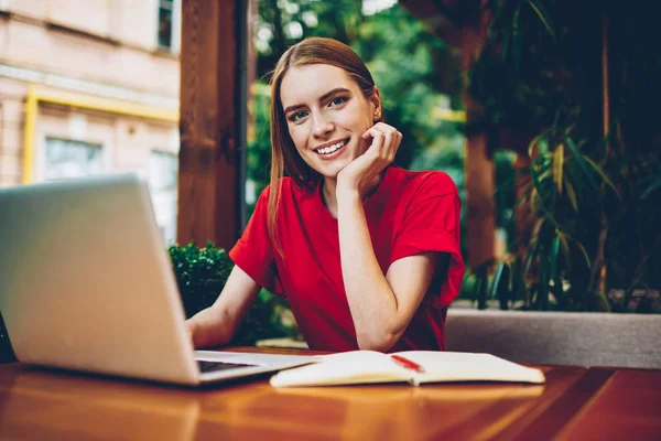 Yarım uzunluk portre çekici kadın sahibi coffee shop online veritabanı sonuçları güncelleştirmek için yüksek hızlı internet bağlantısı ve modern dizüstü bilgisayar kullanarak muhasebe raporları üzerinde çalışıyor