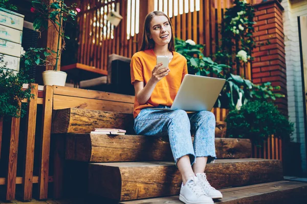 Genç kadın daha iyi telefon parası açık havada yüksek hızlı internet bağlantısı ile web sitelerinde bilgi aramak için dijital dizüstü bilgisayar ile oturup ile yeni tarife planı üzerinde düşünme durulması