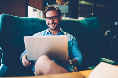 Optik gözlükler dijital dizüstü bilgisayarda yeni modern aracının online sunum izlerken olumlu başarılı adam bağlı 4 g kablosuz internet şık kafe iç oturma