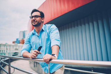 Kendi proje ayakta açık havada ile modern telefon elinde finansal bilgilerinizi için tanıtım alanının yakınında geliştirme üretken stratejisi üzerinde durulması gözlük düşünceli işadamı