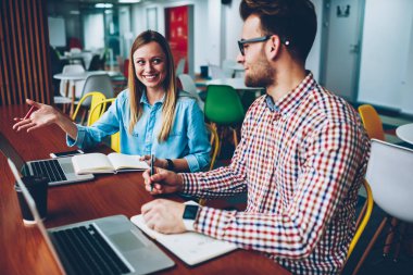 İki yaratıcı öğrenciler dizüstü bilgisayarlar şık coworking, sunu teamworking oluşturmak için ilginç fikirler tartışıyor. Başarılı tasarımcılar birlikte proje hakkında iletişim