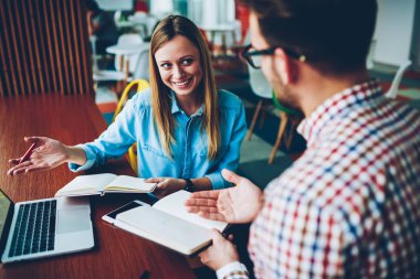 Hipster adam ile tartışma sırasında kendi sratup proje geliştirmek için başarılı fikir hakkında olumlu genç kadın. Neşeli Öğrenciler proje analiz sırasında birbirleriyle iletişim kurmak