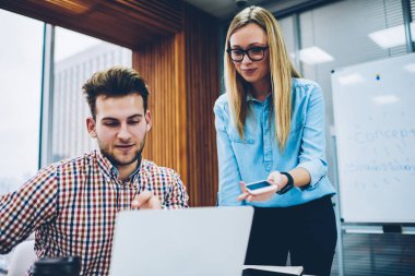 Neşeli kadın öğretmen dizüstü bilgisayar başında oturan yetenekli genç adam için internet sitesi yararlı bilgiler ile gösterilen 4 g için bağlı. Öğretmen ve öğrenci eğitim online sunum izlerken