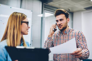Mobil Smartphone cep telefonu ile patron ile kadın arkadaşı ile takım çalışması sırasında konuşmayı genç adam. Üniversitesi'nde nitelikli öğretmen özel ders sırasında telefonla konuşurken hipster öğrenci