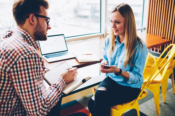 Jonge Man Luisteren Vrouwelijke Collega Met Smartphone Hand Enkele Aantekeningen — Stockfoto