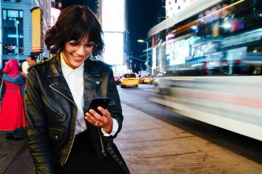 Gözlük smartphone ile gece ışık trafik yakınındaki kentsel settin yürüyüş iyi haberleri ile bildirimde bulunarak mutlu neşeli hippi kız. Pozitif şık blogger cep komik mesaj okuyun