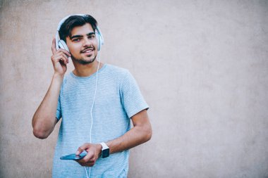Yarım uzunluk portre tanıtım alanının yakınında headpones daimi favori şarkı listesi zevk mutlu hipster Blogger. Smartphone'da neşeli şık erkek meloman dinleme ses müzik app indirilen