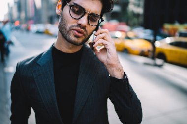 Şık giyim telefon görüşmesinde businesss konuları tartışmaya giymiş başarılı genç gurur CEO'su resim kırpılmış. New York Street Smartphone cep telefonu ile konuşurken akıllı icra müdürü