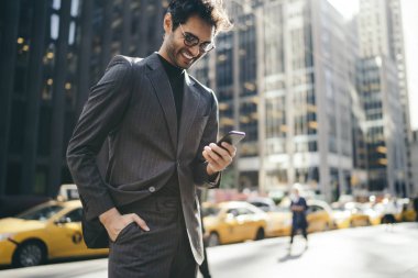 Resmi kıyafetler mutlu erkek girişimci New York sokakta geziniyor Smartphone cep telefonu ile komik bir mesaj aldı. Başarılı işadamı cep iyi finans haberleri ile gelen bildirim okuma