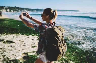 Genç Sarışın Turizm Seyahat sırt çantası shootig tropikal manzara yaz gezisi sırasında keşfetmek modern smartphone cep telefonu ile video ile. Kadın uzun yürüyüşe çıkan kimse yolculuk tutkusu ile fotoğraflar cep üzerinde yapım sırt çantası