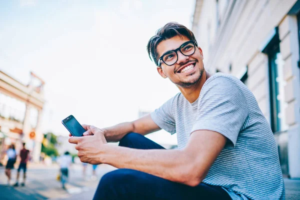 Szczęśliwy Młody Człowiek Oko Okulary Śmiać Trzymając Smartfon Ręku Siedział — Zdjęcie stockowe