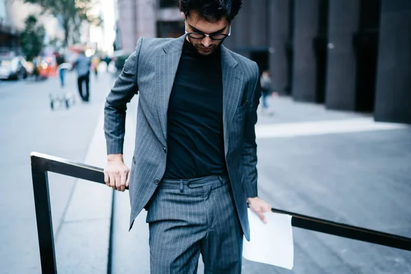 成功したエコノミストのトリミングされた画像を着たファッショナブルな正式なアパレル事務所ビル近く屋外で立って見下ろしています Elegand グレーのスーツで良いの探してビジネスマン — ストック写真