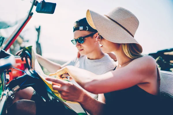Male and female tourist choosing better way for discover nature reading map in convertible rental car,couple driving in cabriolet automobile talking about direction for destination on journey