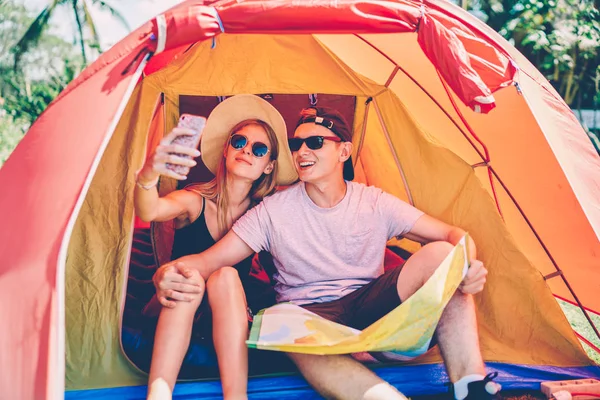 Jovens Turistas Alegres Sentados Tenda Posando Para Selfie Celular Casal — Fotografia de Stock