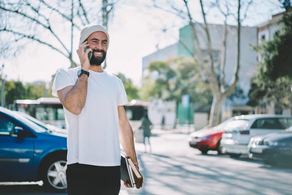 Handsome Cheerful Male Blogger Holding Notepads Hand Talking Modern Telephone — Stock Photo, Image