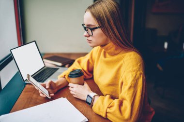 Kişisel Web sitesinde reklam bilgin içerik boş kopya alanı ekranlı dizüstü yanında oturan smartphone içinde takipçileri ile sohbet gözlük içinde kadın blogger resim kırpılmış