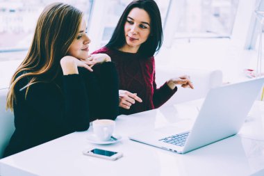 Genç yaratıcı arkadaşları birbirleriyle iletişim kurmak ve başlangıç projesi için serin fikirler birlikte kafede otururken tartışıyor. Dizüstü bilgisayarda çalışma çekici grafik tasarımcıları için 4 g bağlı