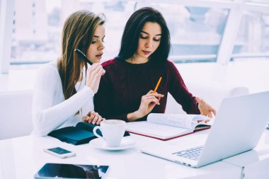 Arkadaşlar ilginç oluşturma hakkında fikirleri tartışmak bloknot Not ve uzay coworking içinde kablosuz internet ile modern dizüstü bilgisayar ile oturup kendi başlangıç projesi geliştirmek için reklam