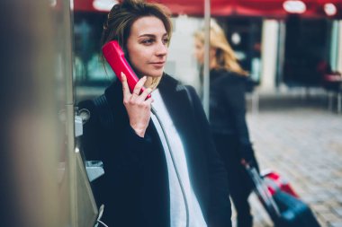Genç kadın turist eski moda genel telefon yolu ile şehir, sokak, dalgın hippi kız arkadaş megalopolis uzağa arıyorsunuz için gezi tur sırasında ödemeli telefon kulübesi kullanarak bağlanma arama
