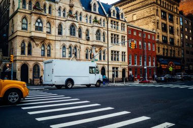 Beyaz minibüs otomobil yer değiştirme ve teslimat için şehir bina, kargo lojistik şirketi moc için dağıtım ve nakliye şirket adı veya logosu şehir alanı yakınındaki sokak Park