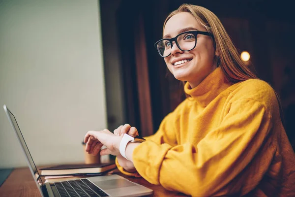 年轻有吸引力的成功女性博客身着时尚的黄色毛衣享受时间在咖啡馆里 华丽微笑的时髦女孩等待会议时对数字 Smartwatch 的检查时间 — 图库照片