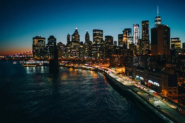 全景式高层摩天大楼建筑附近的河流与房地产豪华公寓照亮夜间 开发了纽约大都市的基础设施与交通和现代建筑 — 图库照片