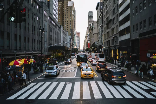 大城市生活与拥挤的街道和出租汽车汽车在路控制由交通灯在区与现代建筑学 出租汽车和汽车停在人行横道附近大厦商业区 — 图库照片