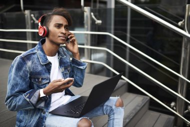 Yetenekli düşünceli hindu öğrenci kulaklık ses ders sırasında dil öğrenme netbook bluetooth üzerinden bağlı. Durulması erkek blogger çalma listesinde yüklemek için Web üzerinden müzik dinleme