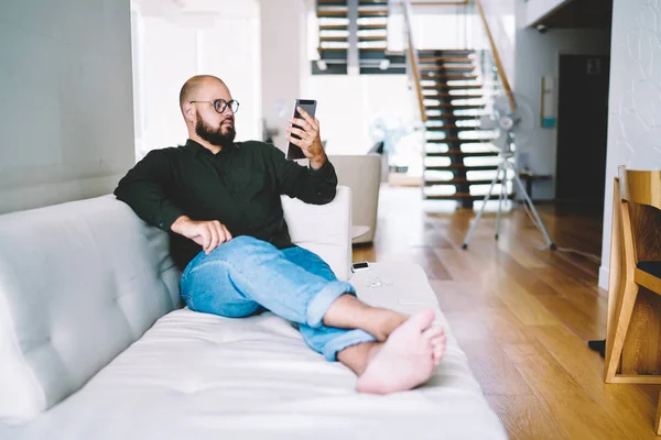 소파에 즐기는 집에서 수염된 남자가 수염된 Hipster 아파트에 현대적인 패드에 — 스톡 사진