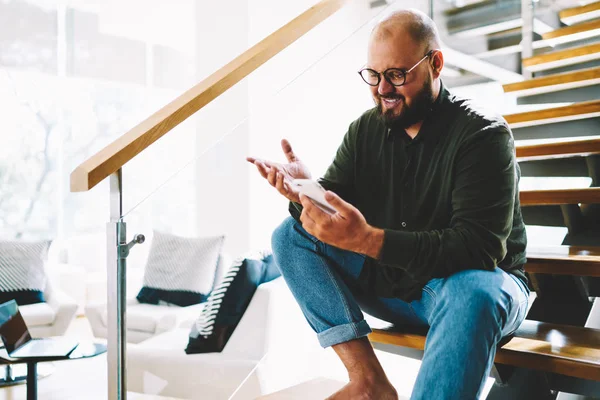 Munter Med Skjeggvekst Blogger Øyeklær Ser Online Livstrøm Smarttelefon Hjemmetelefon – stockfoto