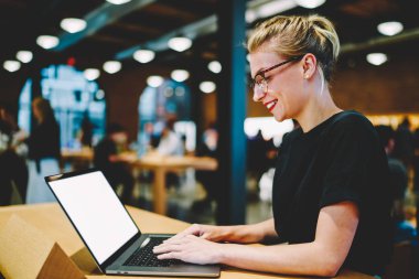 Genç çekici gülümseyen erkek blogger boş kopya alanı ekran reklam bilgin içerik ile Laptop Kişisel Web sitesi içinde takipçileri ile sohbet keyfi moda giysiler giymiş