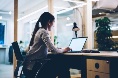 Arkadan görünüm office fazla mesai raporu, bilgi aramak ile boş ekran dizüstü bilgisayar kullanan akşam geç vasıl okul sırası oturan kadın çalışan tamamlamak için kalan kadın işkolik
