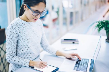 Deneyimli kadın Sekreter yolu ile netbook, yetenekli kadın İdari Yöneticisi işlem düzenleme dijital tablet üzerinde planlama yapma ile eşitleme touchpad app belgelerin imzalanması