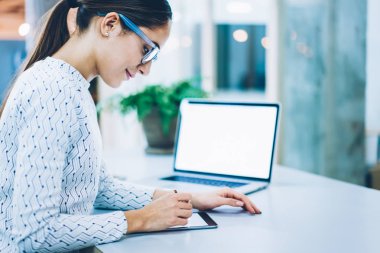 Şirketin pozitif kadın yönetici ziyaretçi online yolu ile tablet, işkadını gözlük ayakta imzalama belgelerle masaüstü ekran kalemi, danışmanlık web sitesinde olumlu geri bildirimler ile memnun