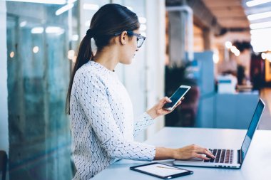 Arkadan Görünüş yeni mesaj, Resepsiyon masası iletişim ve şirket çalışma sürecinde düzenleme posta göndermek için teknolojisini kullanan kadın okuyor telefon tutarak kadın İdari Yöneticisi