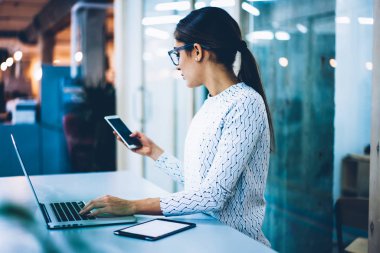 Bildirim iletişim, rezervasyon onayı için yeni mesaj okuma netbook ile masada duran kadın resepsiyonist için teknolojisini kullanarak Smartphone cep telefonu ile kontrol yetenekli idari işler müdürü