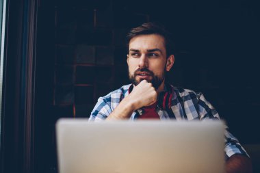 Düşünceli sakallı erkek o serbest modern dizüstü bilgisayar, kablosuz 4 g ile çalışma programı geliştirilmesi üzerinde düşünme profesyonel internet. Yayın için fikirler üzerinde durulması şaşkın genç adam