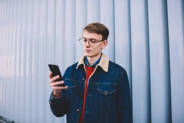 Genç hipster blogger posta denetleme ve takipçileri smartphone ücretsiz 4 g internet bağlantısı kullanma sosyal ağ ile mesajlaşma. Genç online telefon ayakta kentsel ortamda sohbet