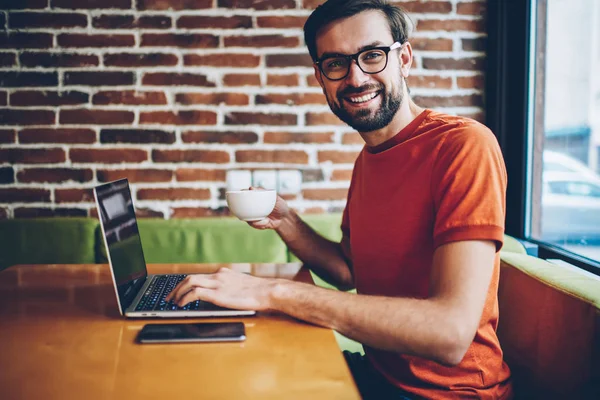 Retrato Del Exitoso Joven Barbudo Freelancer Sonriendo Cámara Mientras Sostiene — Foto de Stock