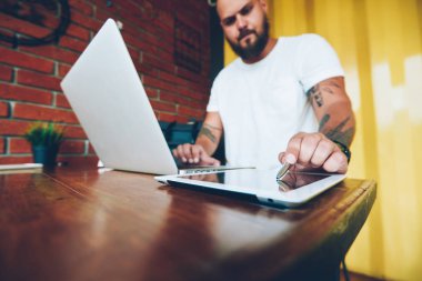 Genç erkek grafik tasarımcı çizim kroki touchpad üzerinde düzenleme online, stylos ve uygulamalar aracılığıyla bankacılık yapma dijital tablet qaimənin imzalama işadamı için dizüstü bilgisayara bağlı