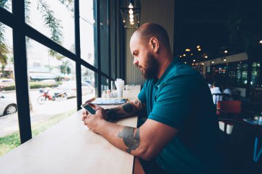 Sosyal ağlar içerik ara kafeterya, yaratıcı erkek bolgger takipçileri ile bir paylaşım cep telefonu ve wifi kullanarak multimedya sohbet ile smartphone ile yeni güncelleştirmeleri denetlemeyi genç hipster adam