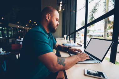 Uzak iş, konsantre adam bilgi online kurslar öğrenme e için arama netbook klavye için sahte ekran ve wifi kafeteryasında ile dizüstü bilgisayar kullanan yetenekli erkek serbest meslek