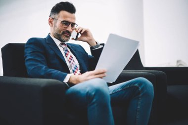 Bilgi veri okuma ve gülümseyen ve çalışma office smartphone iç iş ortağı ile konuşurken muhasebe raporları kontrol formal giyim başarılı deneyimli girişimci