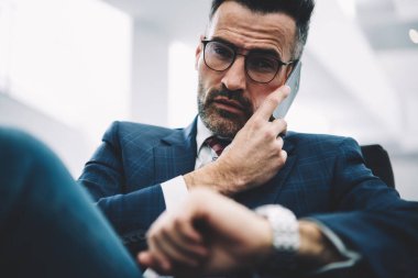 Kendine güvenen ofis çalışanı 50 yaşında iş ortağı ile kameraya bakarken smartphone telefon görüşmesinde konuşurken portresi kapatın. Ciddi meşgul gurur ceo arama cep üzerinde