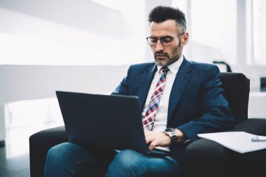 Modern lapto bilgisayarda çalışan ve 4 g üzerinden posta kontrol formal giyim konsantre olgun girişimci Internet. Kendine güvenen gurur CEO'su 50 yaşında arama Web sitesinde bilgi modern netbook üzerinde