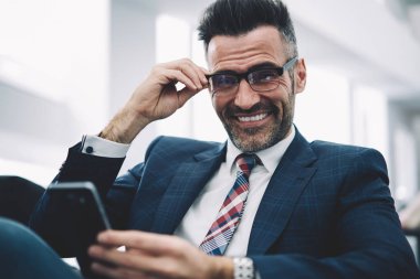 Mutlu başarılı iş adamı 50 yaşında kameraya gülümseyen smartphone online ödeme yapmadan yarım uzunluk portre. Elinde modern telefon ile resmi aşınmaya olumlu gurur ceo